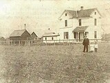 Charles Kelp and two of his children in front of Home